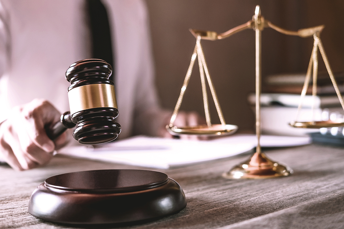Gavel on wooden table and Lawyer or Judge working with agreement
